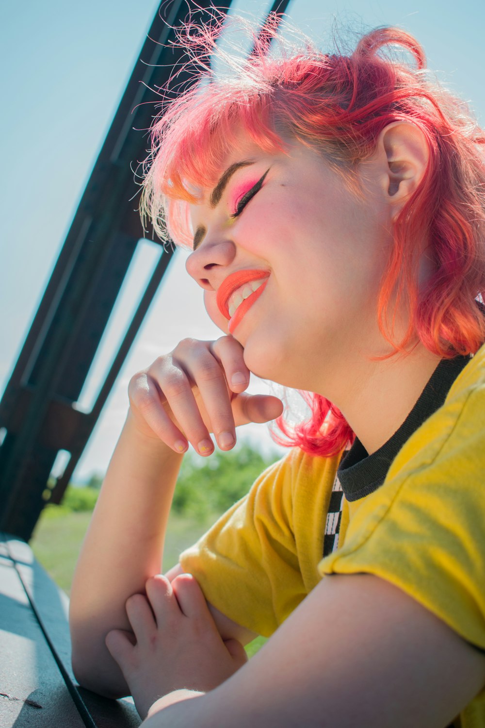 smiling woman leaning on metal bar