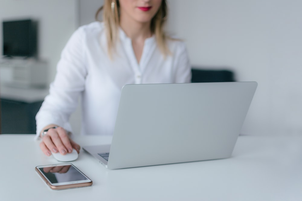 mujer sentada y usando MacBook Air y Apple Magic mouse