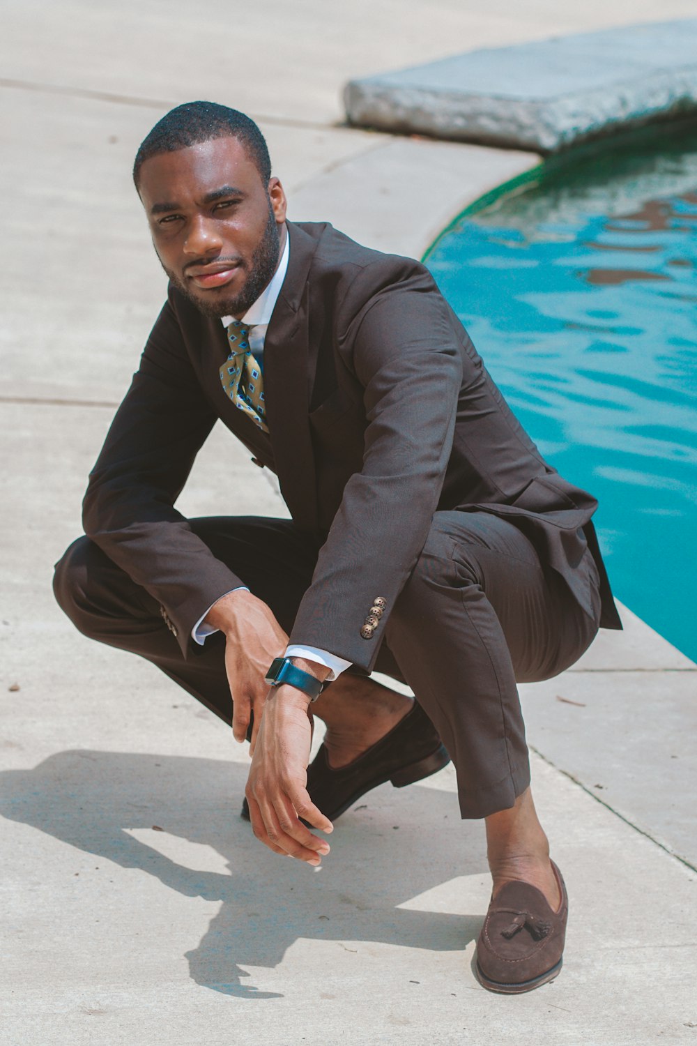 man in black 2-piece suit near swimming pool