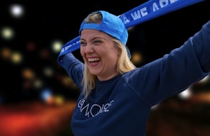 A smiling customer trying on a blue cap in front of a mirror inside the lebparsa store