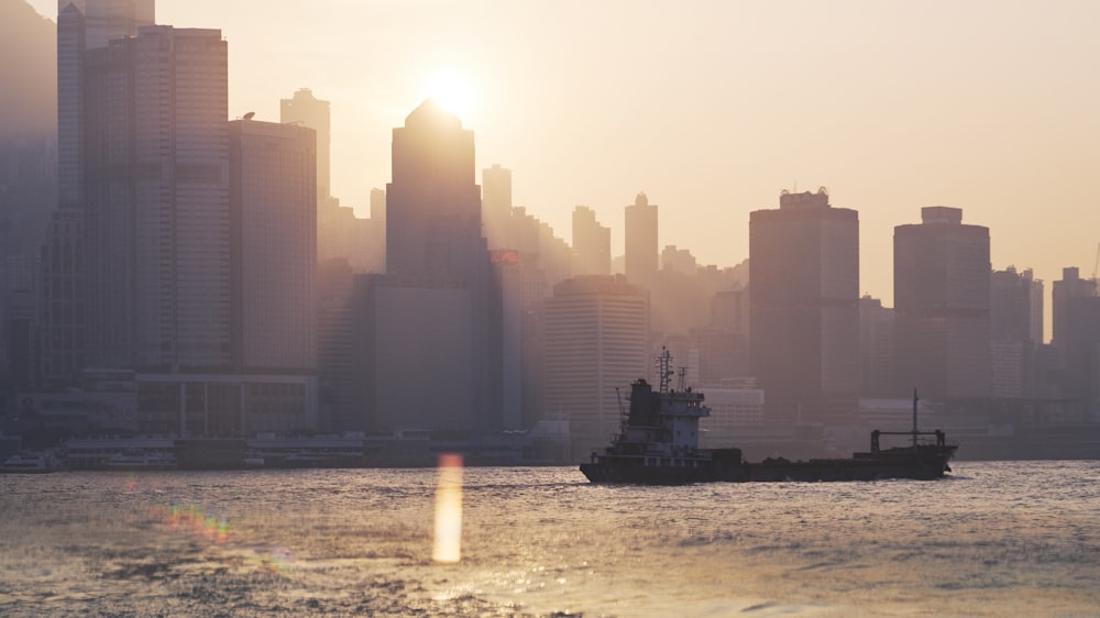 white ship on body of water in front of city buildings