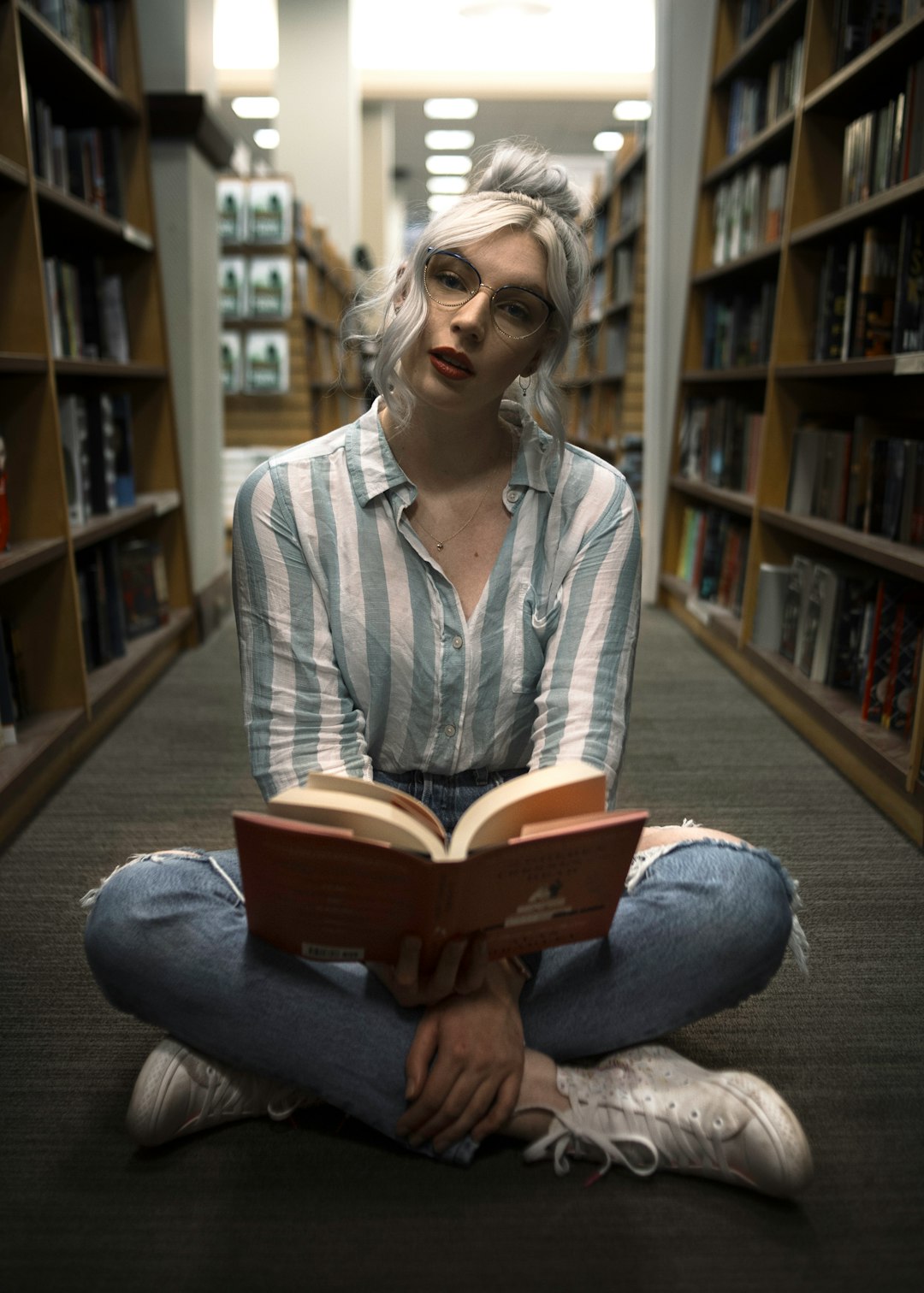 woman sitting near book rack