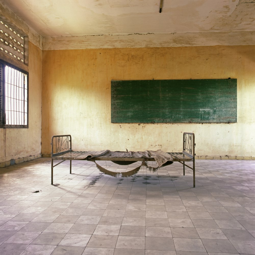 Cadre de lit en métal à l’intérieur de la chambre avec tableau noir monté