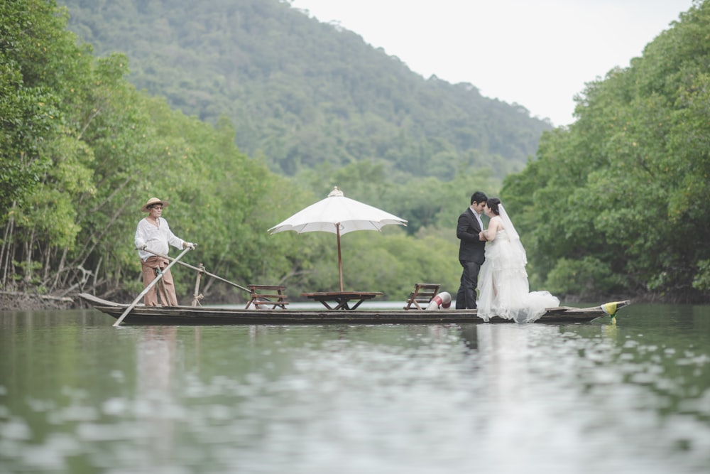 wedded couple riding boat at middle of lake