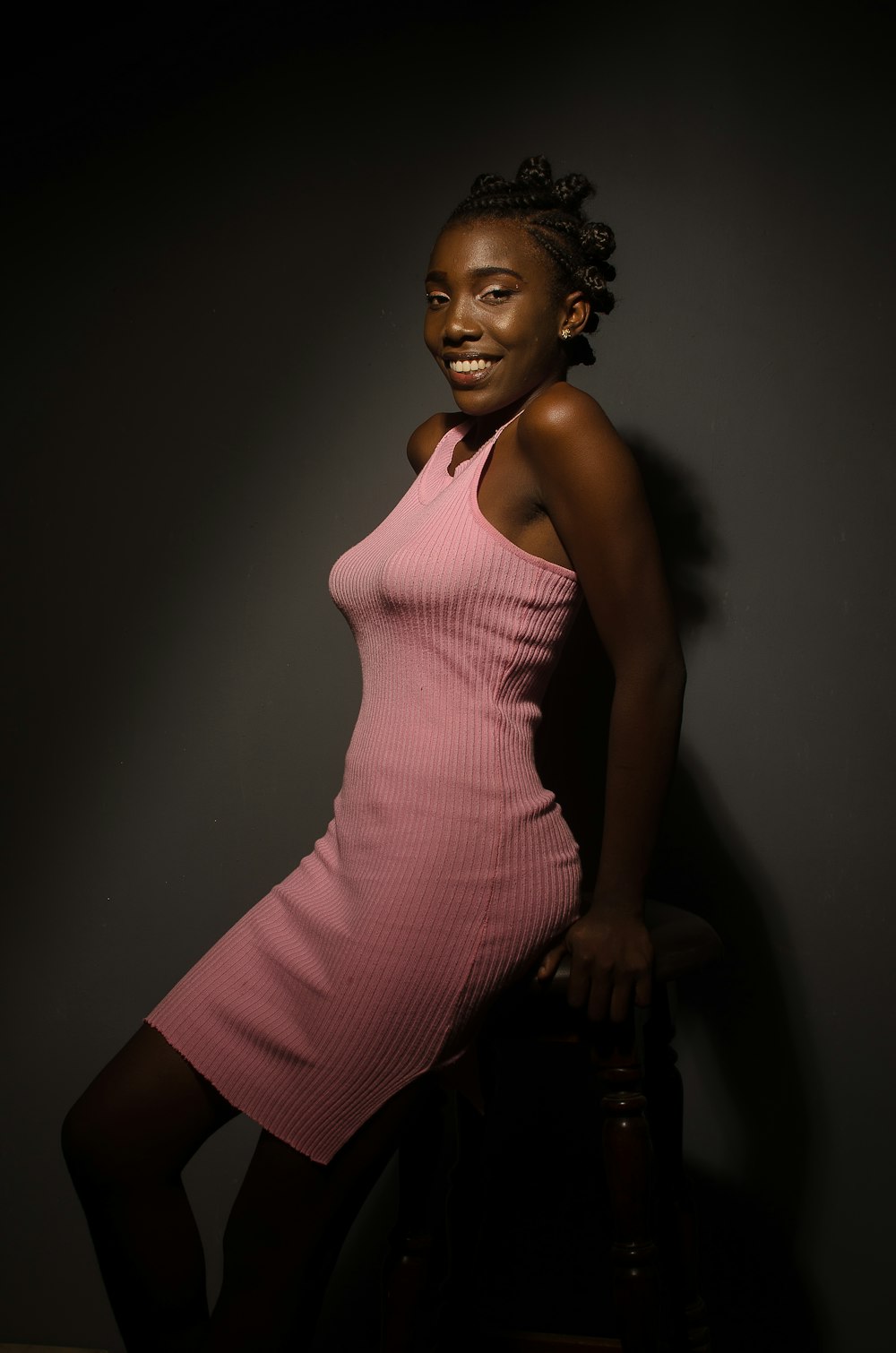 smiling woman in pink sleeveless midi dress