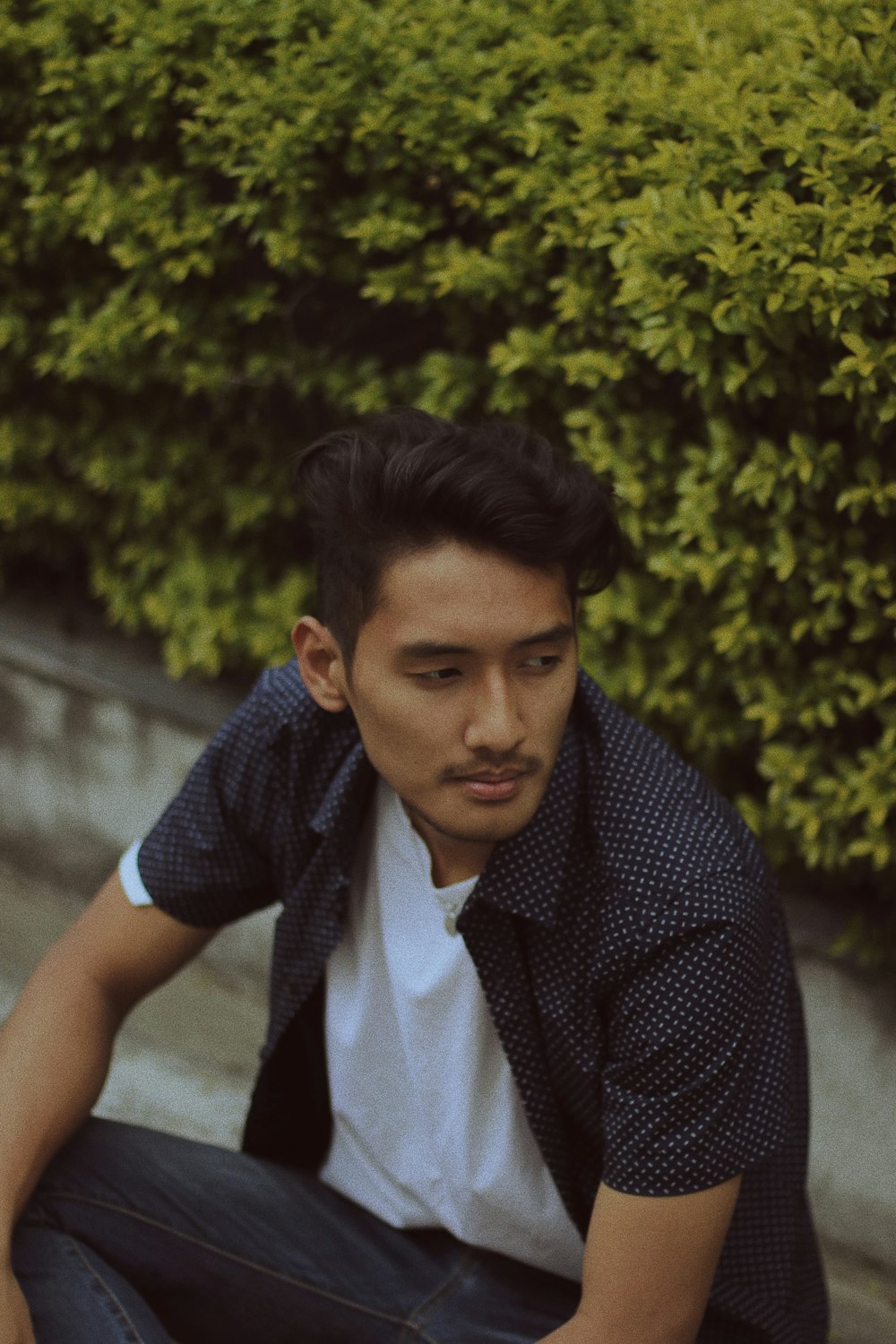 man sitting near plant