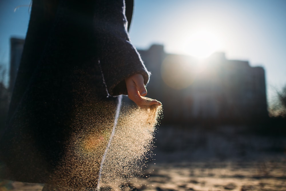 person holding brown sand