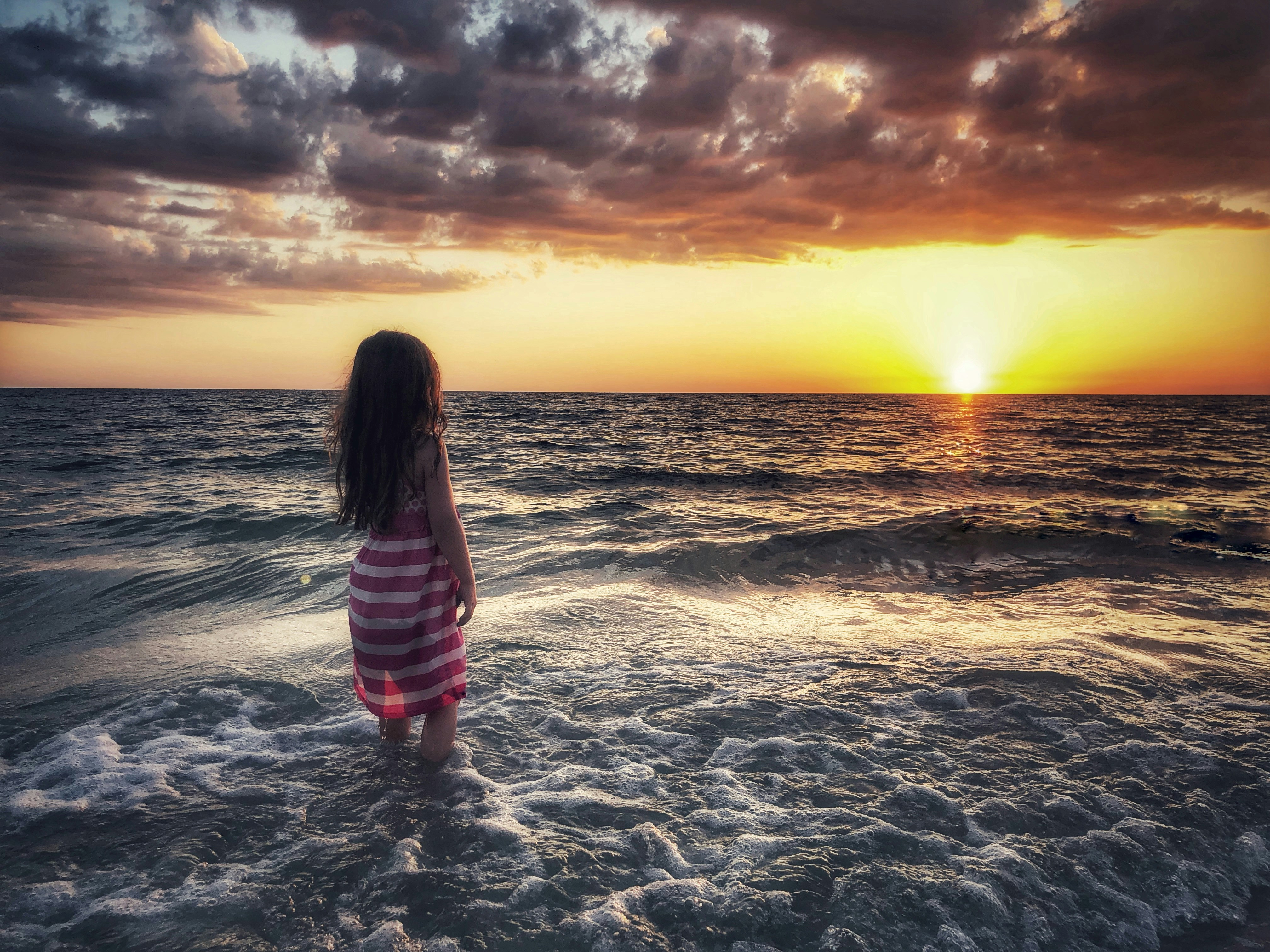 woman standing beside seashore during daytime