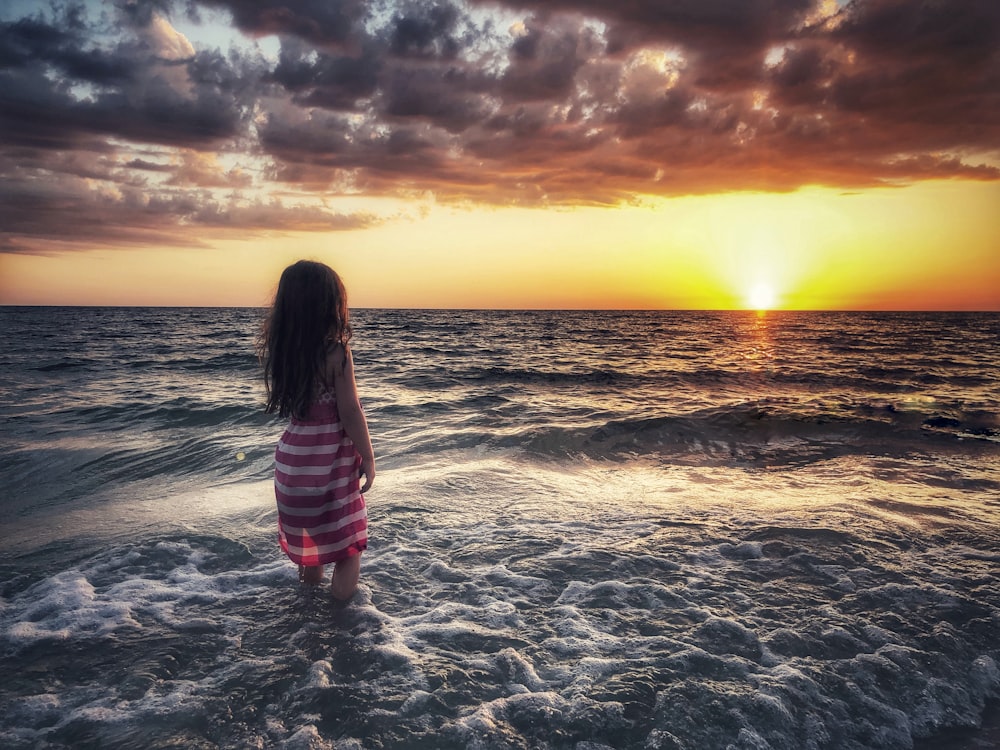 woman standing beside seashore during daytime