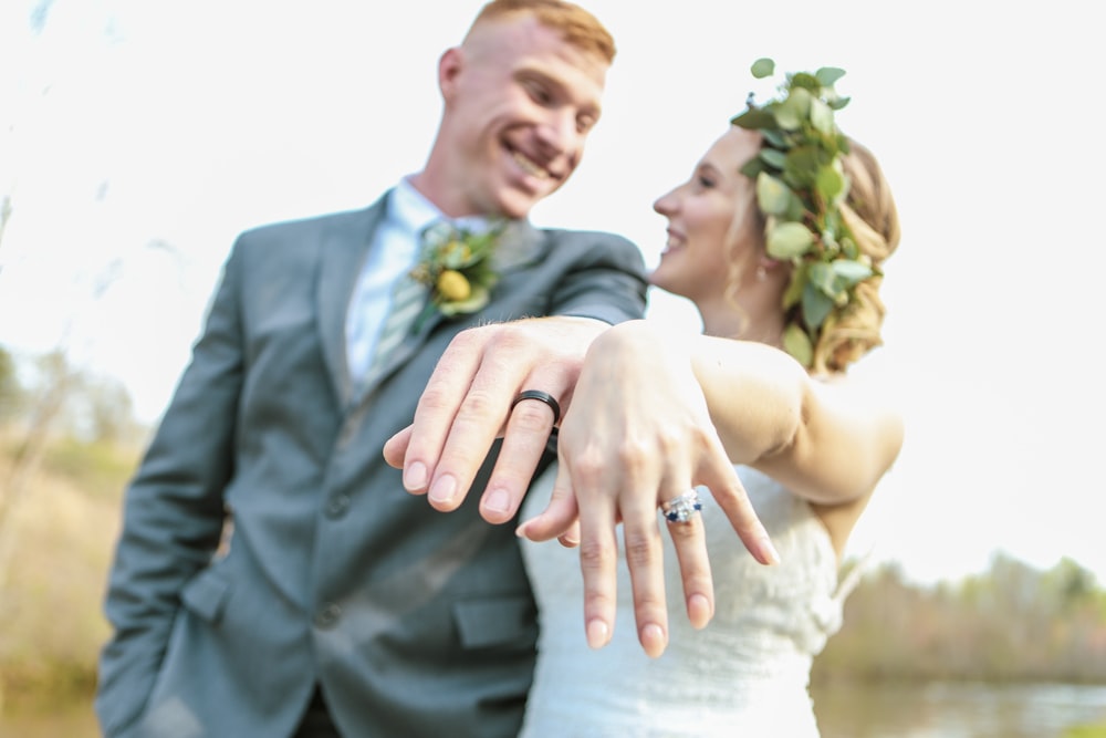 selective focus photography of smiling man in gray suit and woman in white wedding dress