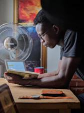 A person thoughtfully reading course reviews on a laptop.