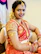 Close-up of a beautifully draped saree with intricate embroidery, worn by a happy customer.