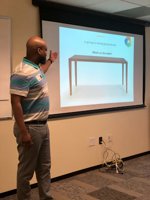 An instructor explaining project management concepts on a digital screen.