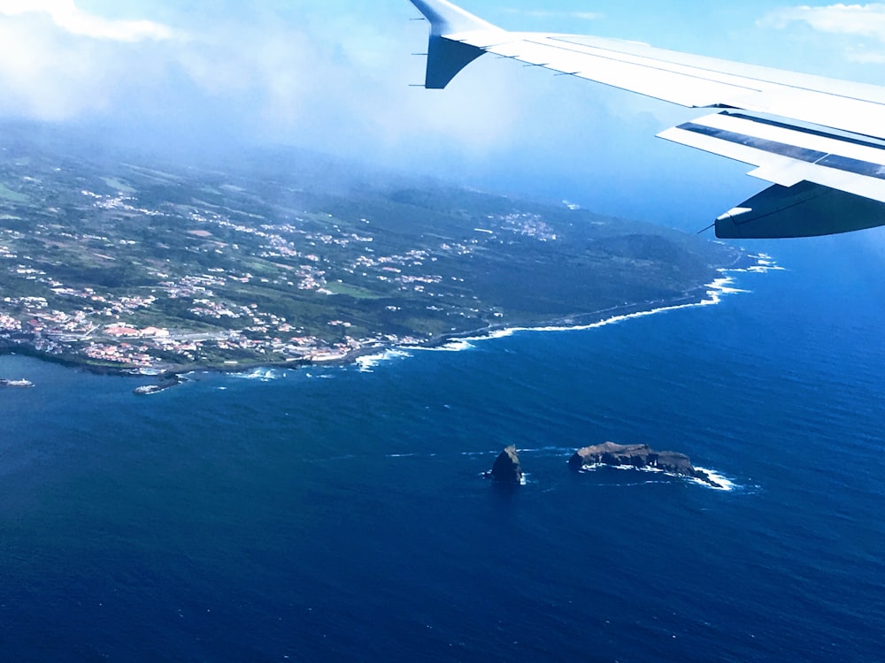 Vista de la ventana del avión del océano y la ciudad durante el día