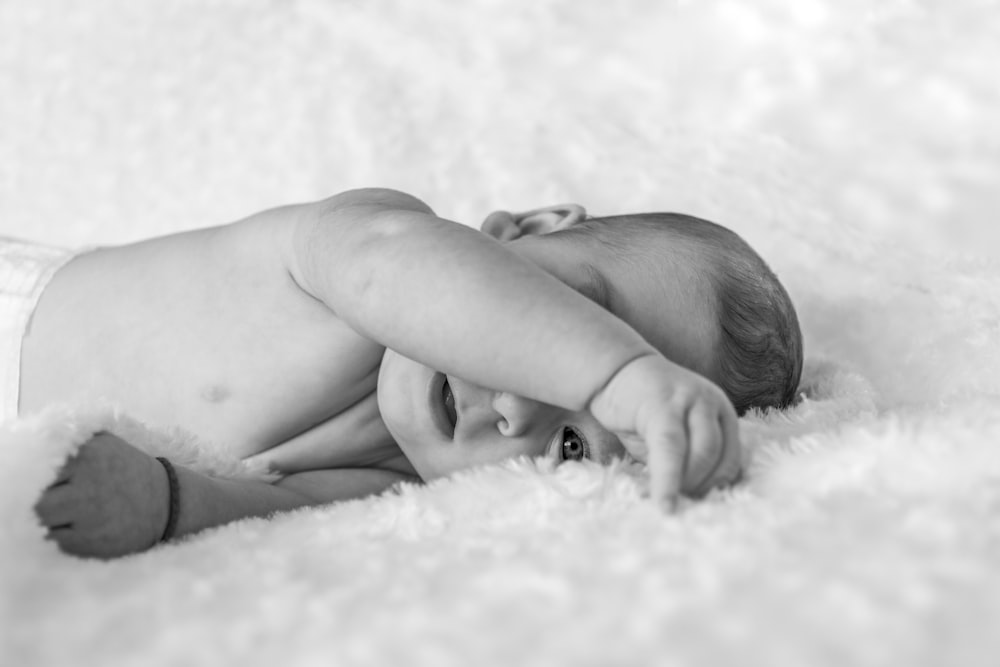 topless baby lying on fleece