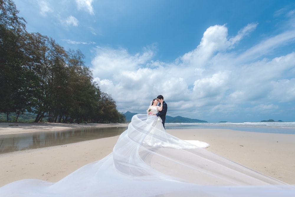 woman and man standing on beach during daytime