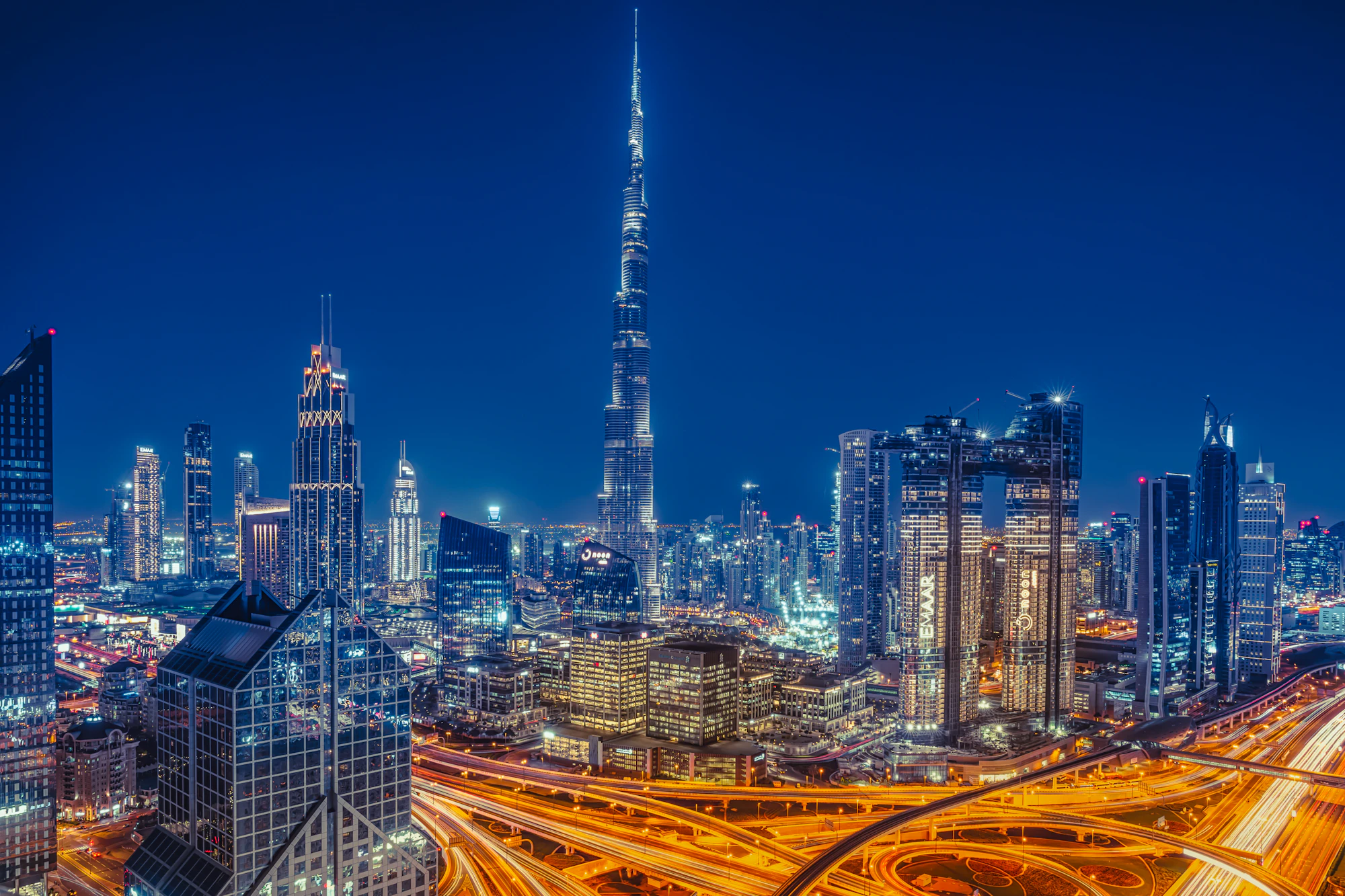 The Burj Khalifa towering over the illuminated Dubai skyline at night
