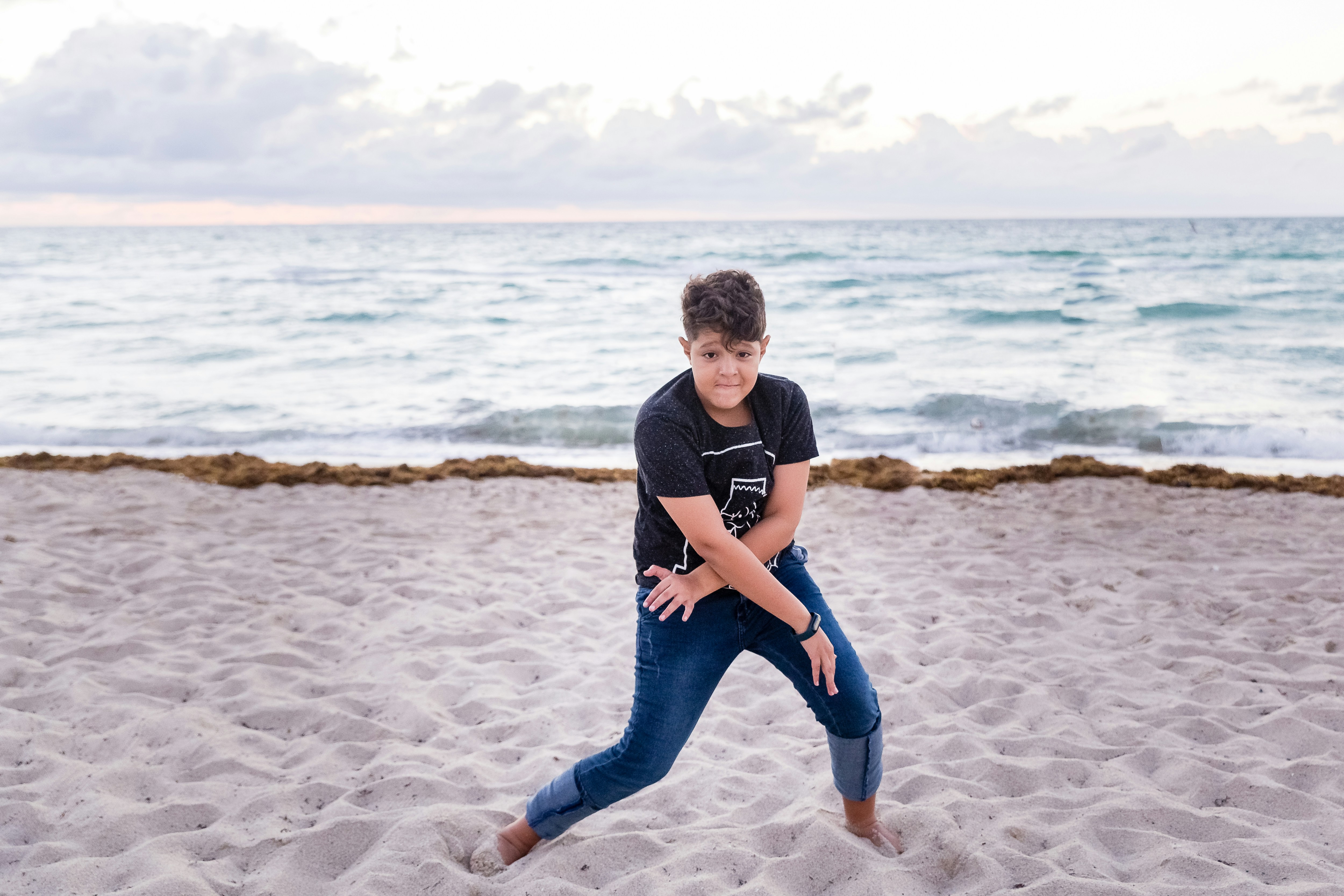 man in black t-shirt and blue jeans standing on shore