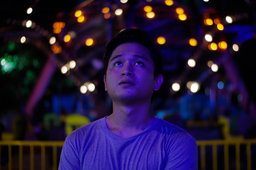 bokeh photography of man near yellow fence