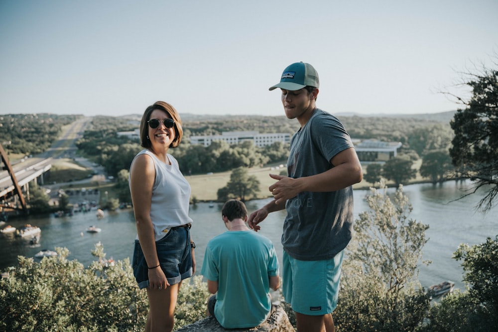 woman and men on cliff facing river