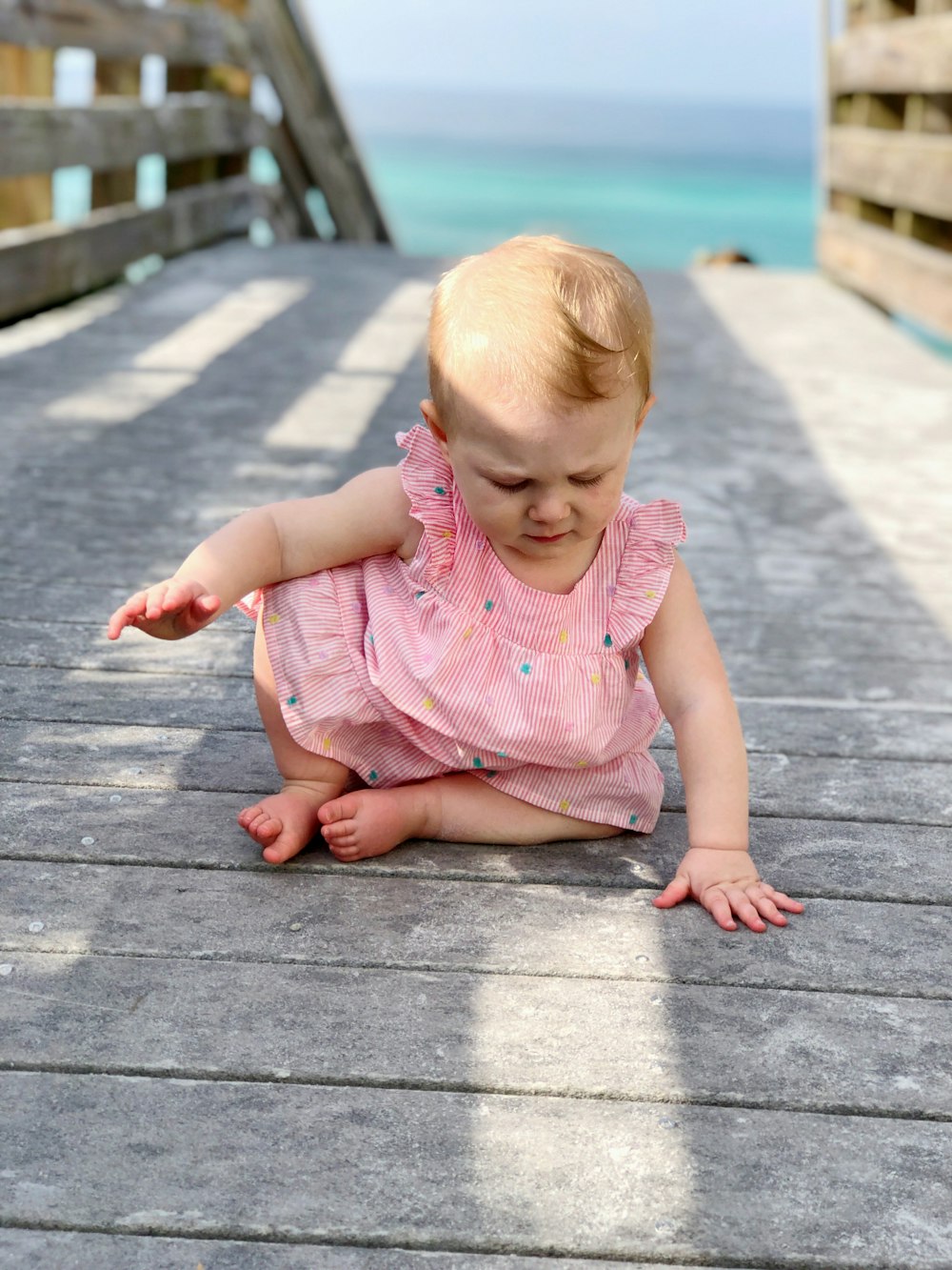 baby sitting on bridge