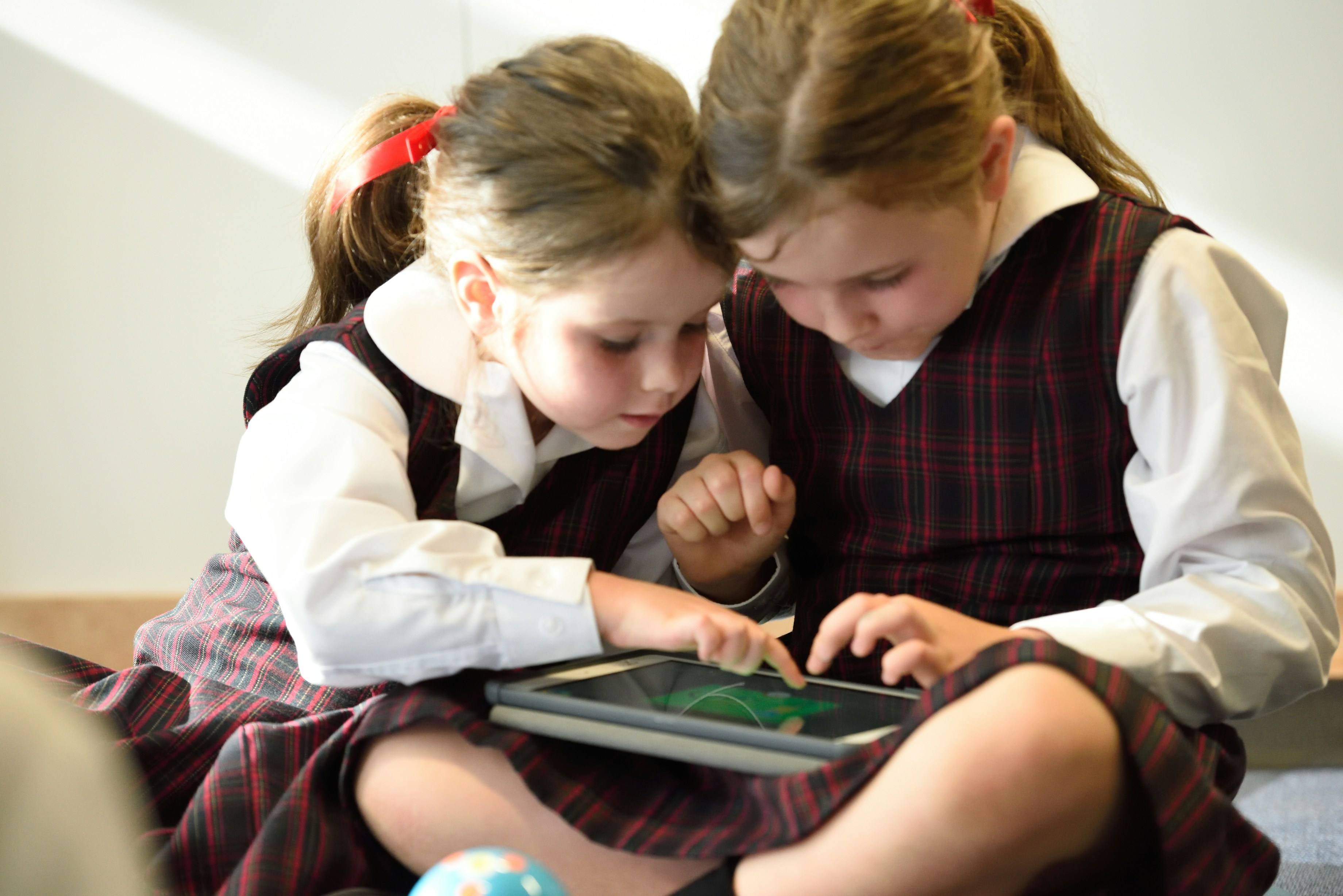 two girls playing tablet computer