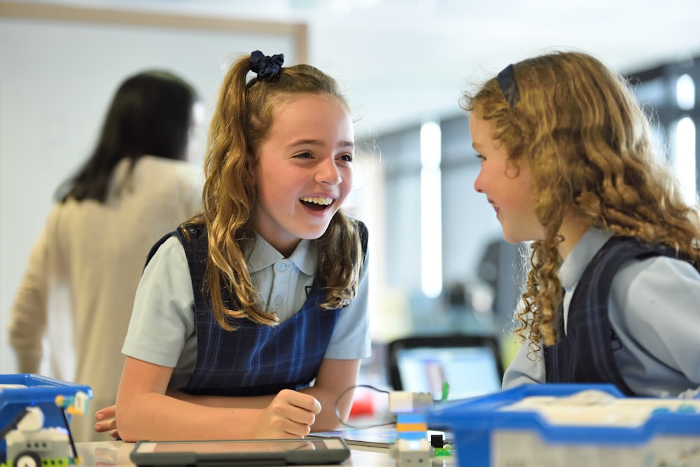 two girls chatting and laughing inside white room