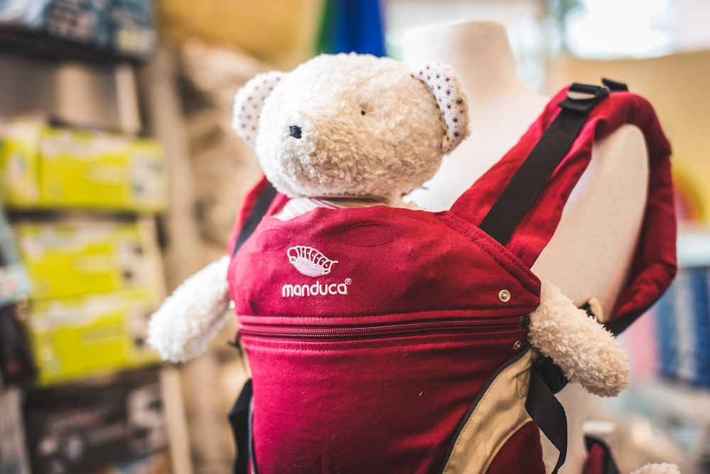 shallow focus photo of gray bear plush toy on red carrier