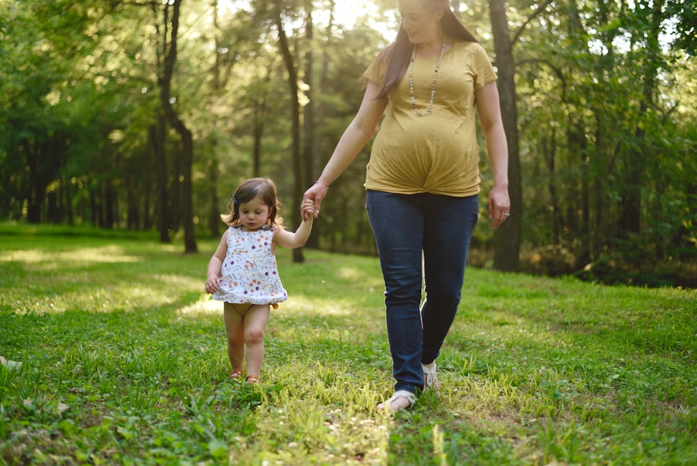 pregnant woman walking beside girl