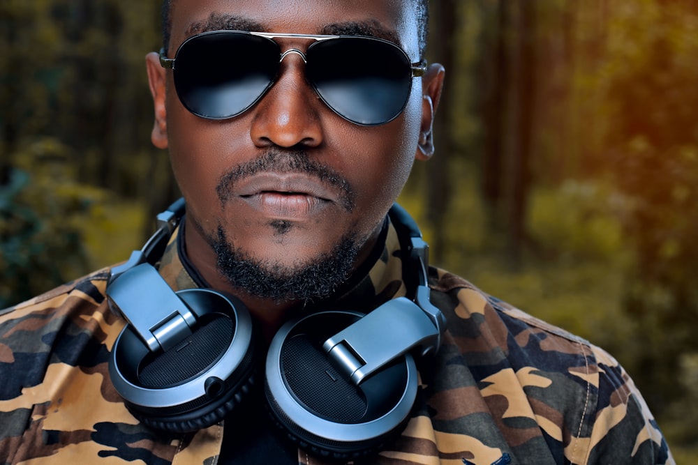 man wearing sunglasses and grey and black headphones