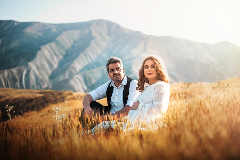 man and woman sitting next to each other with mountain view