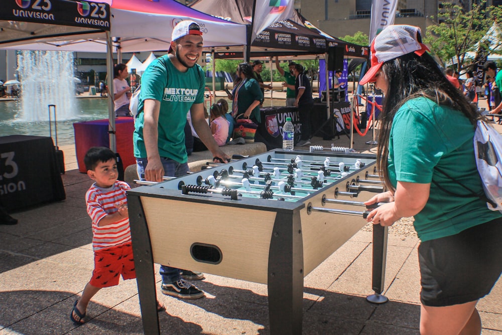 man and woman playing foosball table near booths