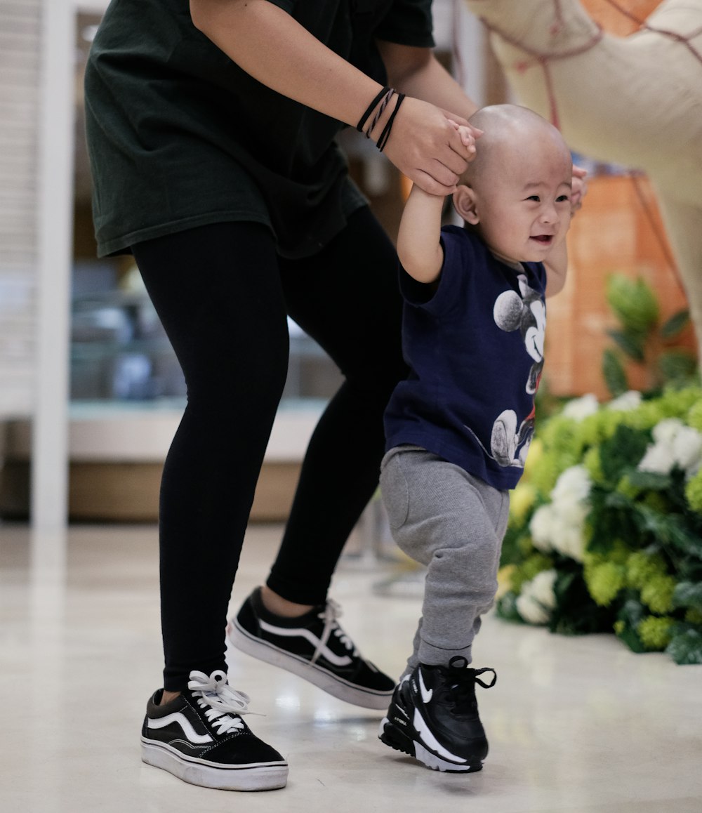 person holding boy's hands while walking