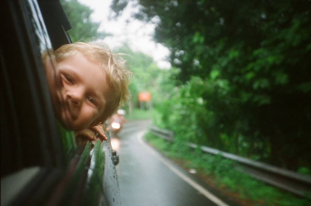 bambino che sbircia dal finestrino del veicolo