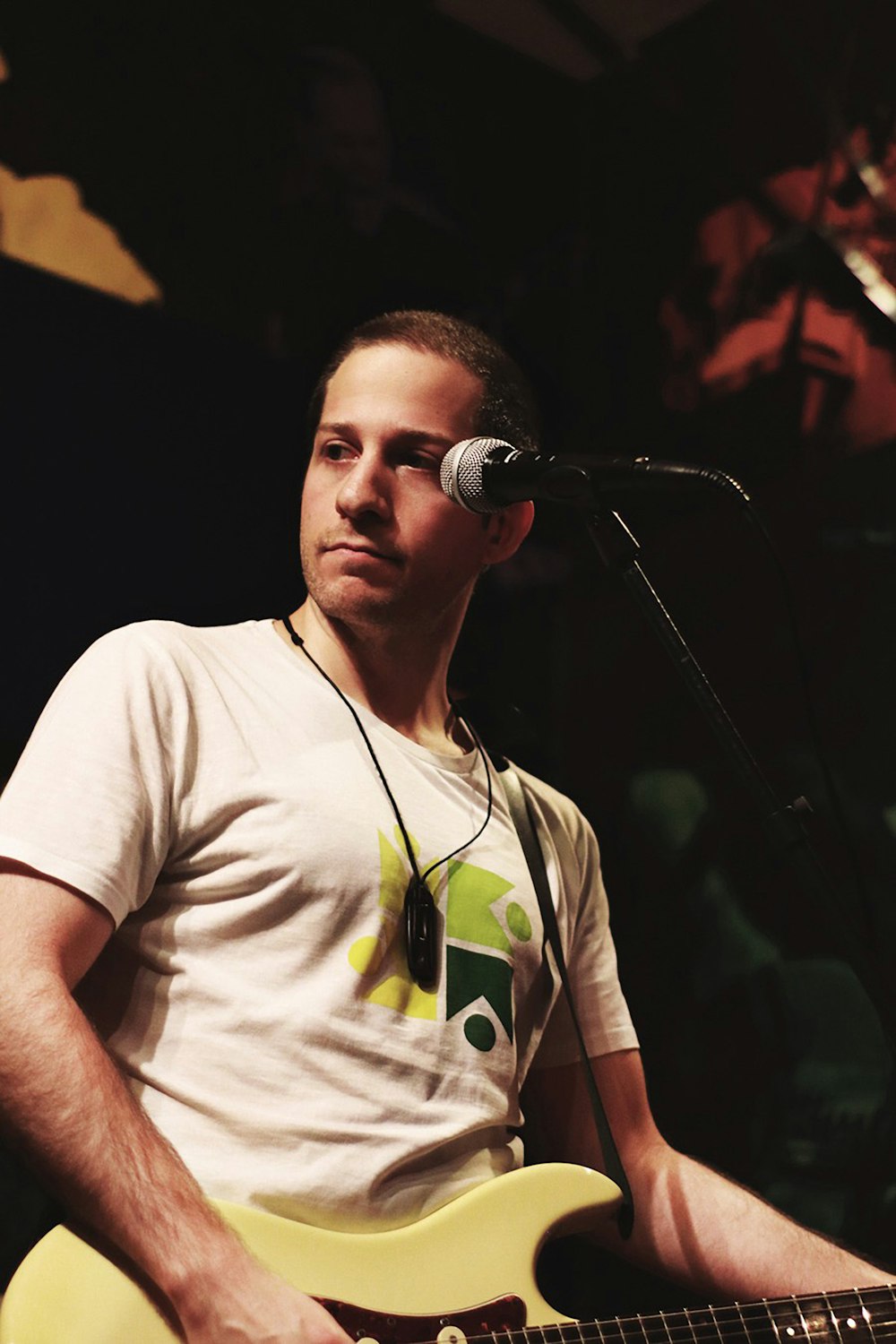 man wearing white shirt playing guitar