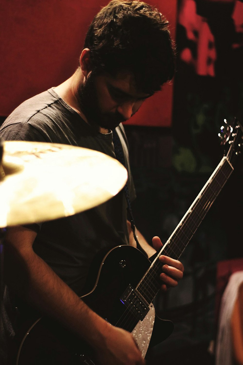 man playing black electric guitar