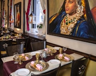A chic dining area adorned with tasteful table settings and art.