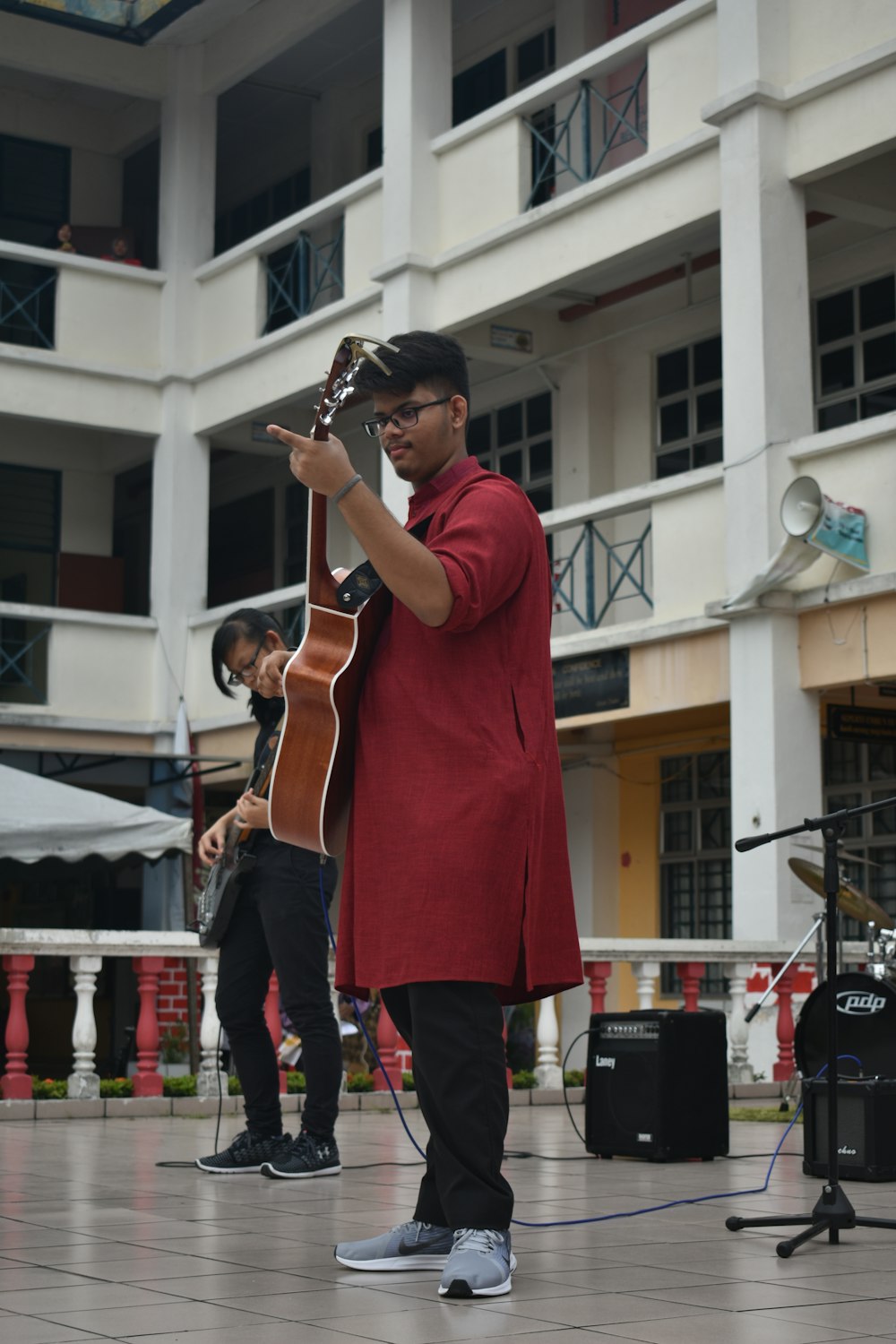 man playing brown guitar