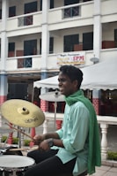 A smiling teenager playing the keyboard with others clapping along in the background.