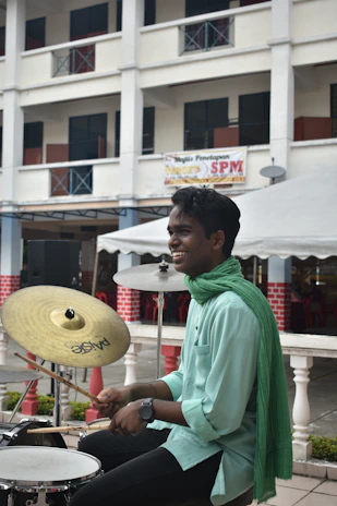 The musician smiling warmly while tuning the handpan before a session.