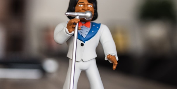 man singing figurine on selective focus photography