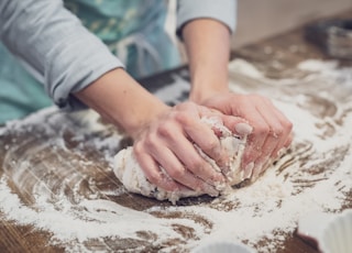 person standing and making dough