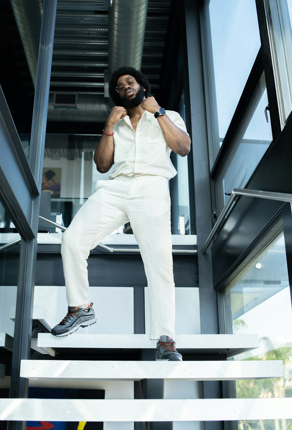 man in white shirt and pants standing on stair