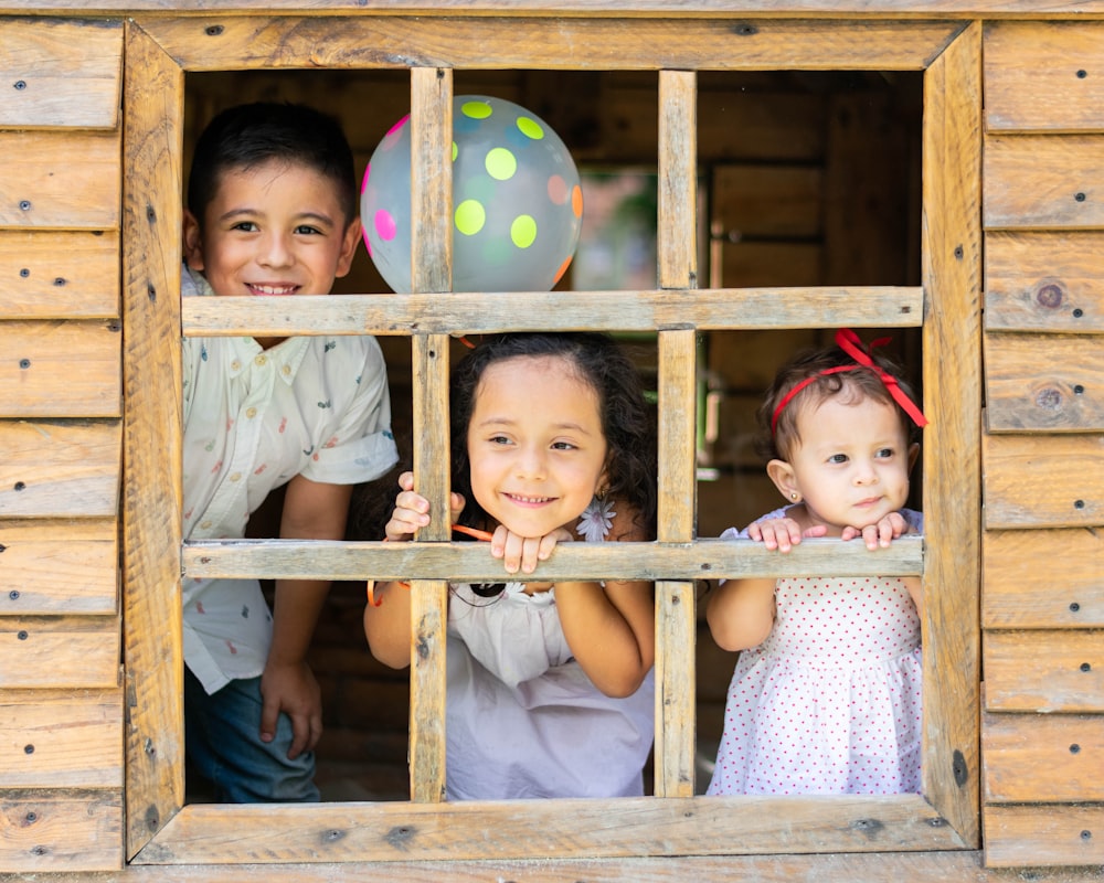 niños pequeños que se asoman a la ventana