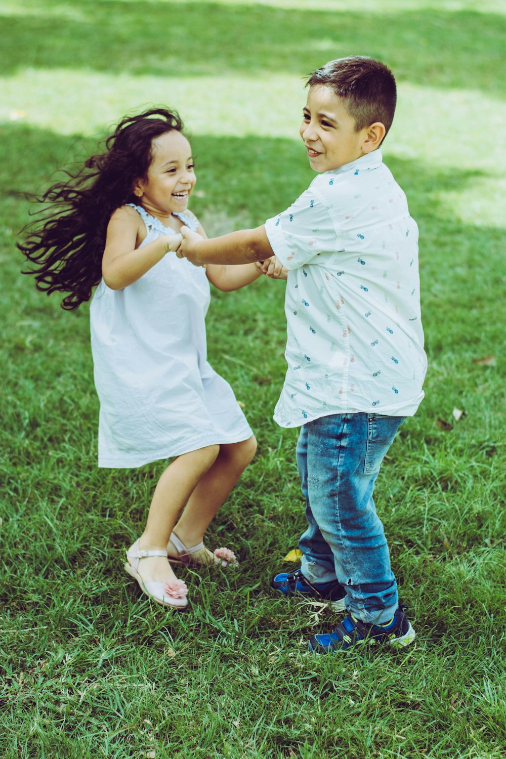 menino e menina em pé no campo de grama