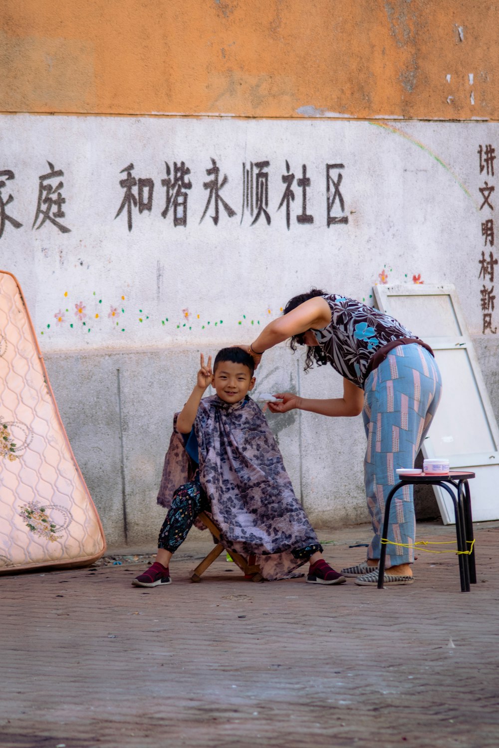boy sitting on stool beside standing woman near wall