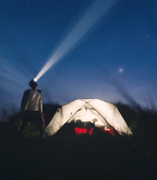 man with headlamp in front on camping tent in Batangas Philippines