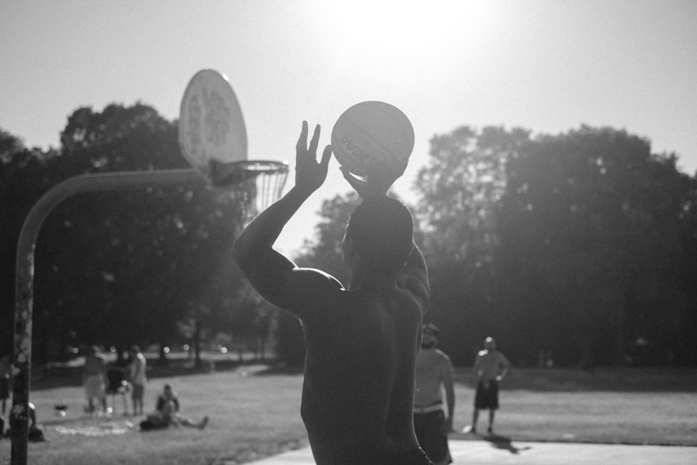 Foto in scala di grigi di un uomo che gioca a basket