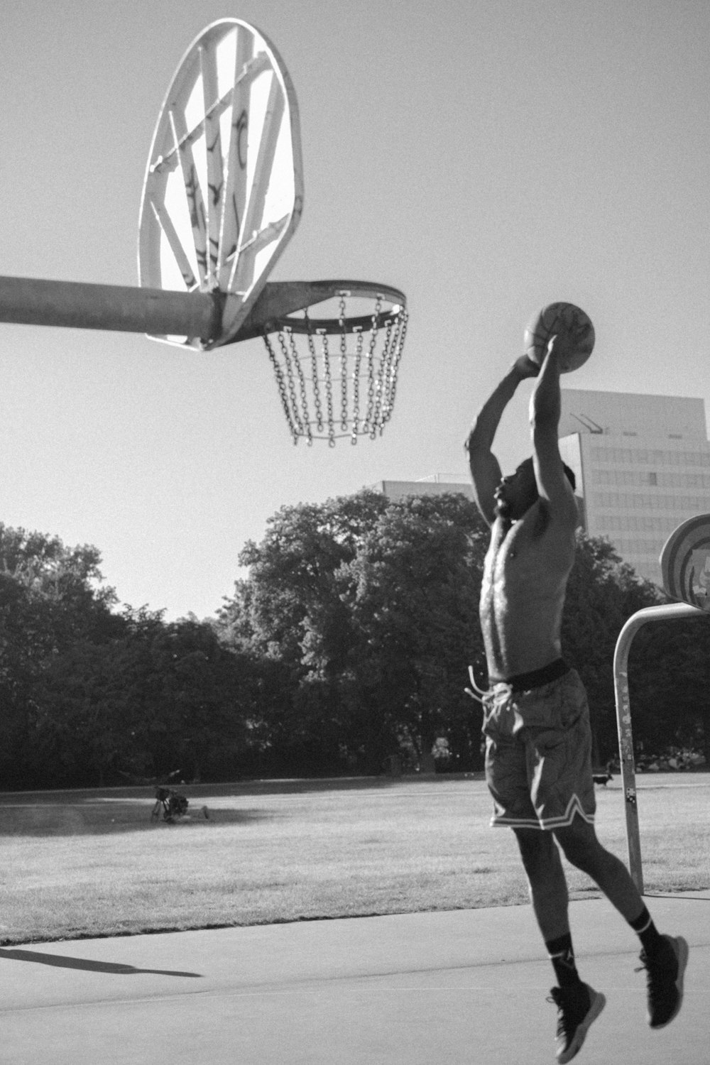 grayscale photography of man playing basketball