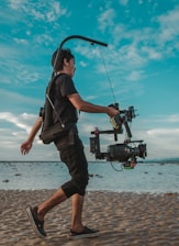 A vibrant behind-the-scenes shot of a creator filming a travel vlog on a sunny beach.